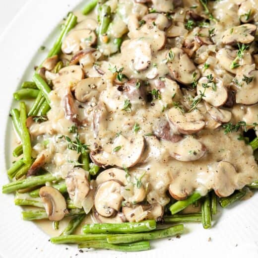 Close-up of roasted green beans with homemade mushroom sauce on top.