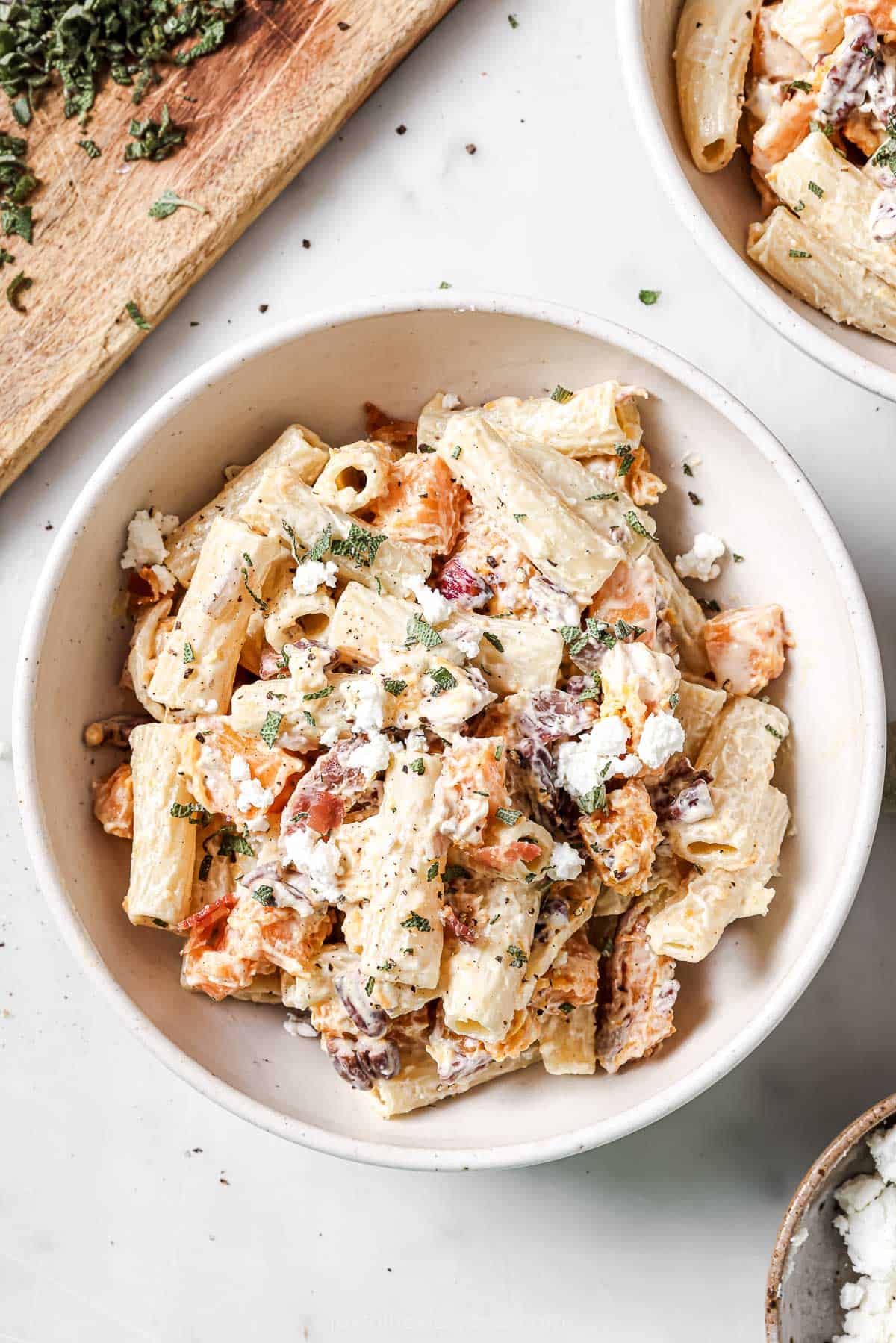 Creamy goat cheese pasta in a bowl with sweet butternut squash, smokey bacon, red onions, and crunchy pecans.