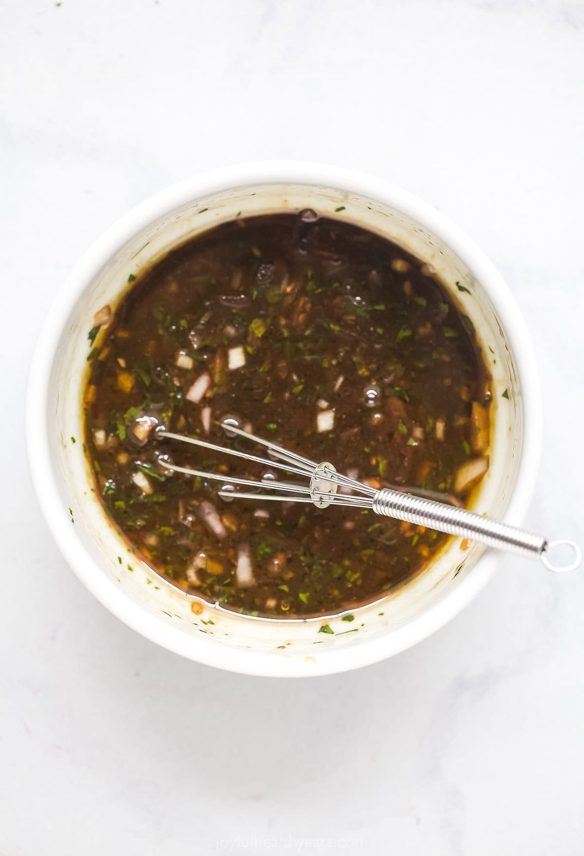 Shallot vinaigrette in bowl with whisk