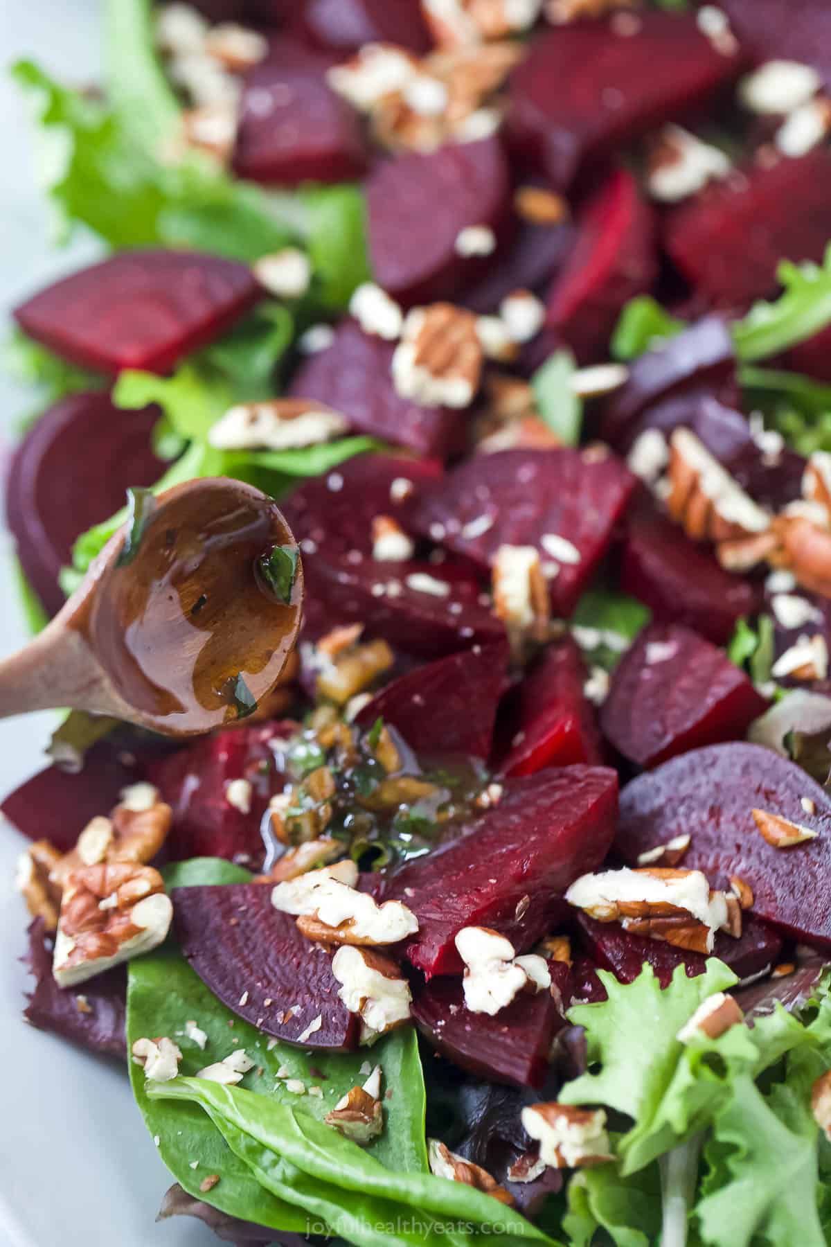 Drizzling vinaigrette onto beet salad