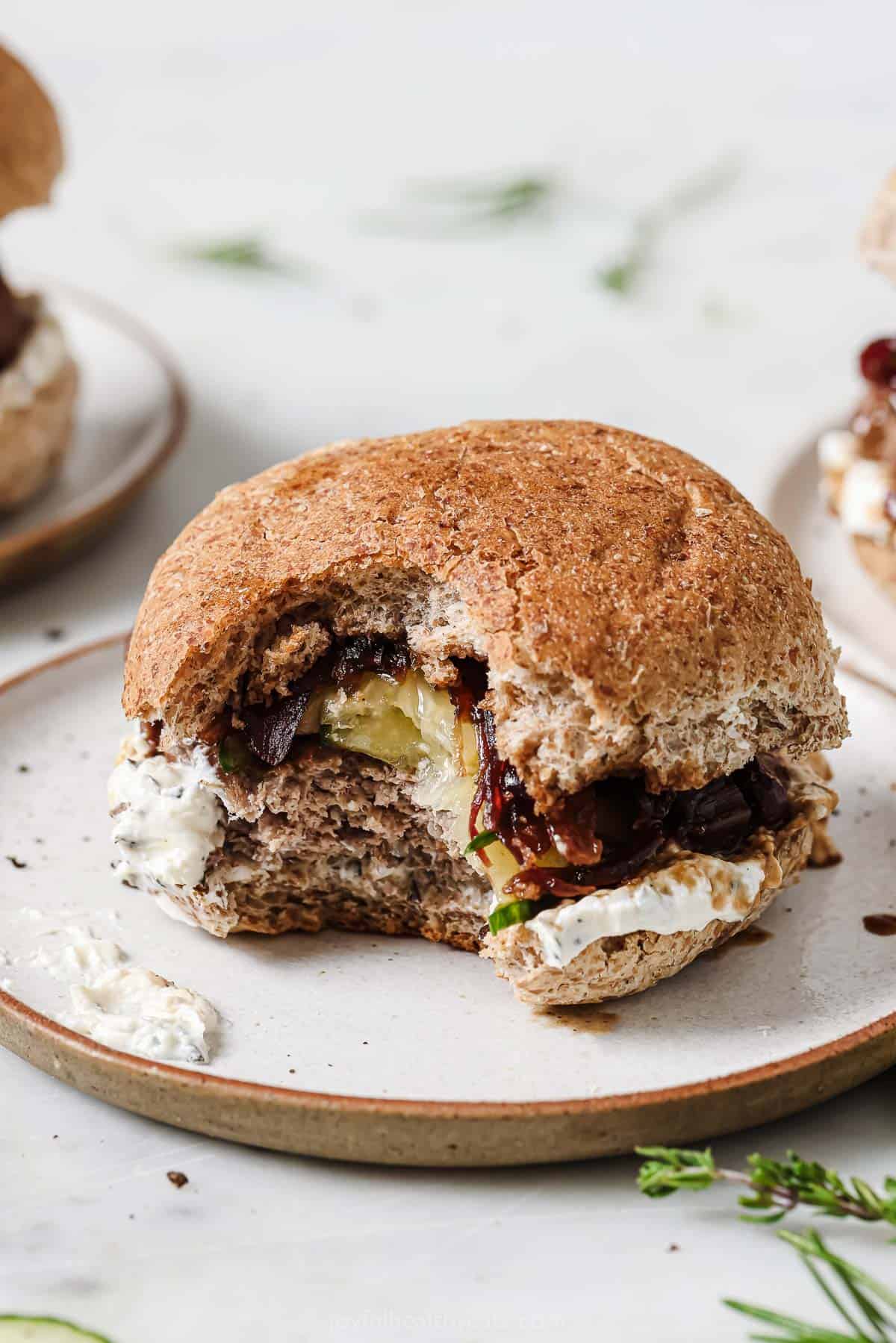 Bitten-into burger with herby whipped feta spread. 