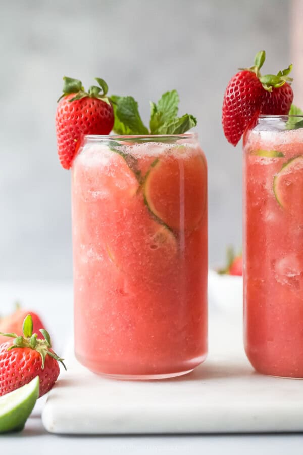 Two glasses of icy strawberry limeade.