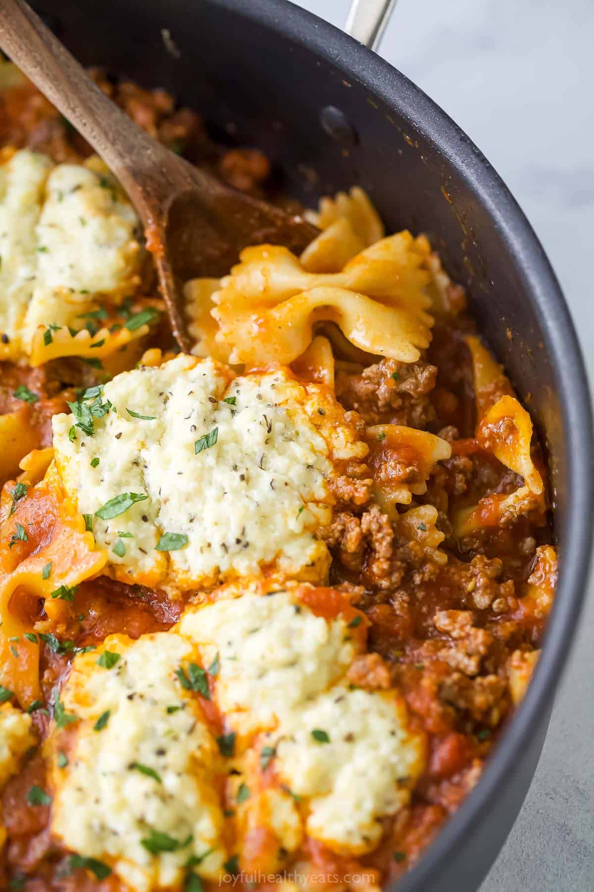 Freshly-made beef lasagna with tomato sauce and ricotta in the skillet. 