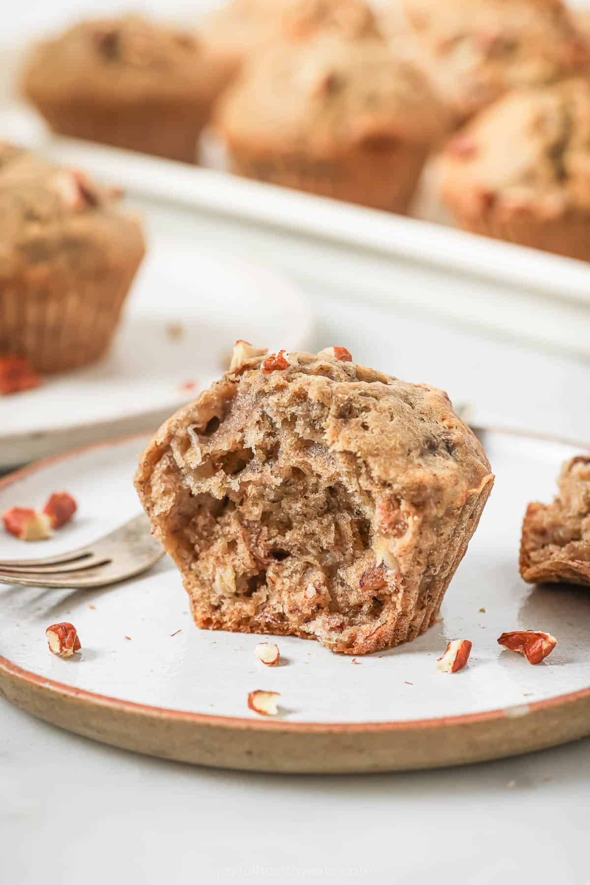 Digging into a fluffy muffin with chopped pecans. 