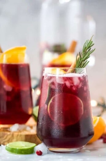 the ultimate holiday sangria recipe in a glass with garnishes