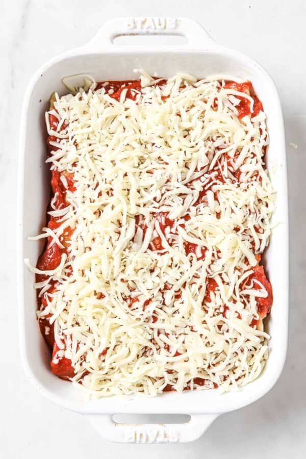 Topping the lasagna rolls with more sauce and mozzarella. 