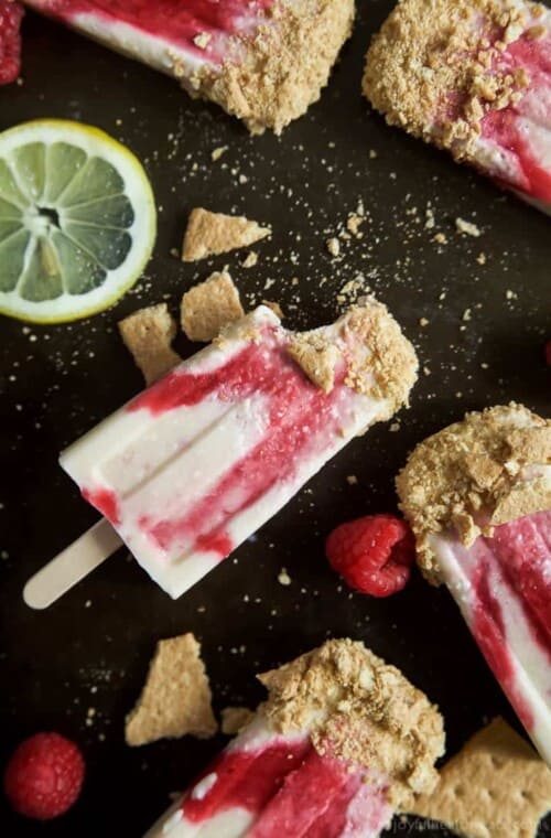 Lemon Raspberry Cheesecake Popsicles, creamy, lemony and filled with fresh fruit. The perfect refreshing treat to cool you down this summer, they taste just like biting into a real cheesecake except half the calories! | joyfulhealthyeats.com