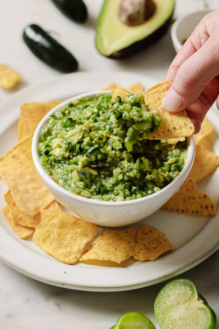 Dipping a tortilla chip into Mexican salsa verde.