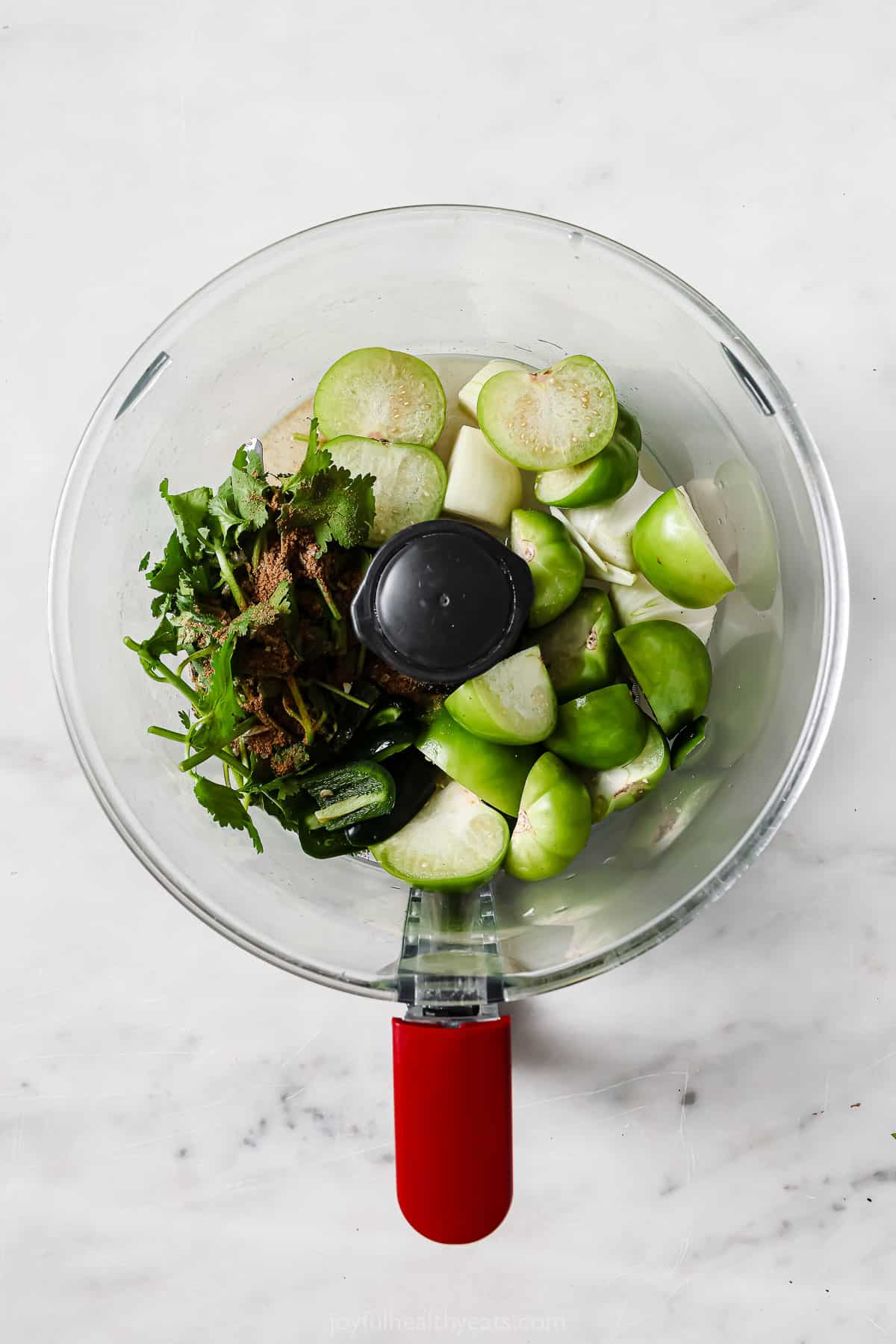 Adding all of the ingredients, except the avocado, to the food processor. 