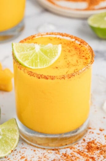 Frozen mango margarita with a lime wedge.