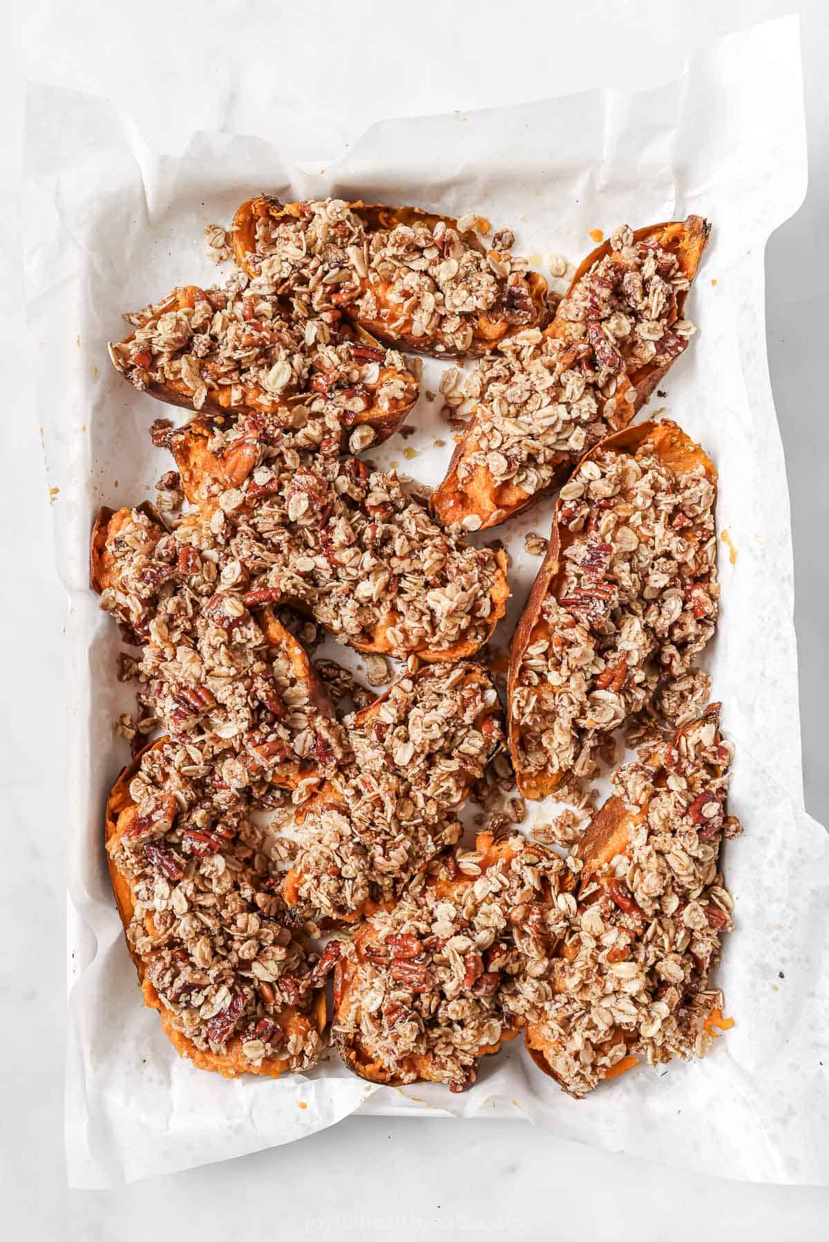 Topping the sweet potatoes with raw streusel, right before baking.