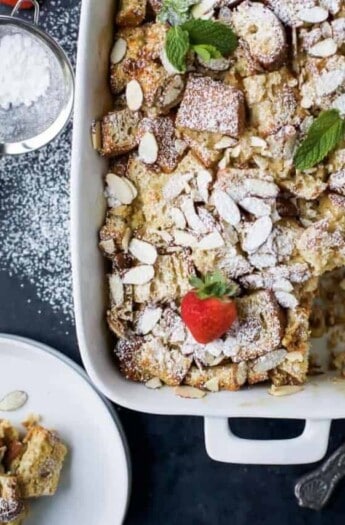 A Christmas casserole topped with powdered sugar and fresh strawberries