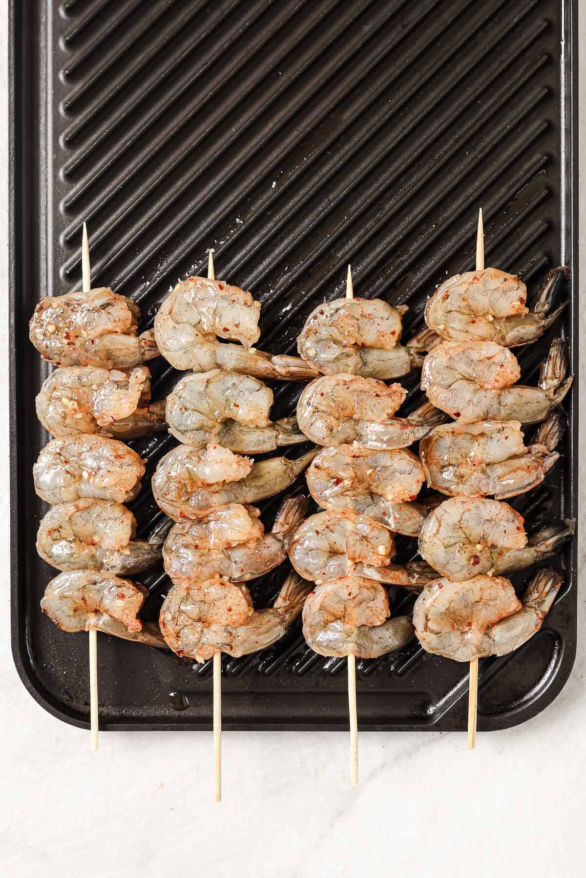 Raw shrimp skewers on the grill.