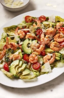 Shrimp caesar salad with grilled lettuce, avocado, tomatoes, and homemade dressing.