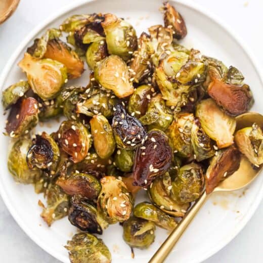 Bowl of homemade honey roasted Brussels sprouts with sesame seeds on top.