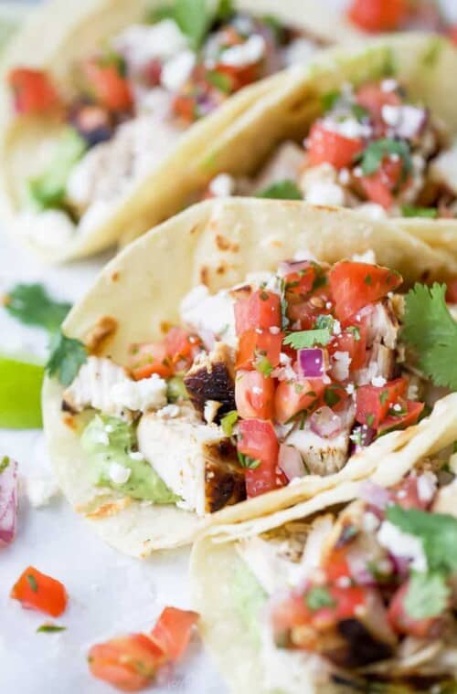 cilantro lime chicken tacos with pico de gallo in them