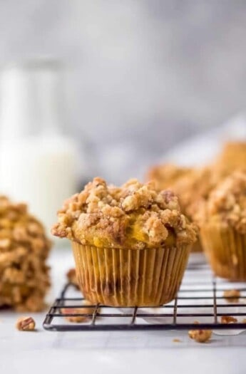 pumpkin muffin topped with cinnamon pecan streusel sitting on a baking rack