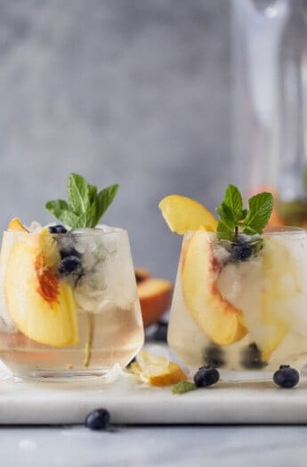 Two peach sangria glasses side by side.