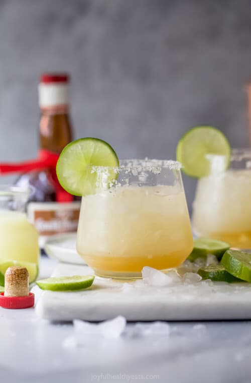 Cadillac margarita with ice and a lime wedge.