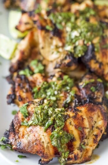 Close-up of grilled chicken with chimichurri on top.