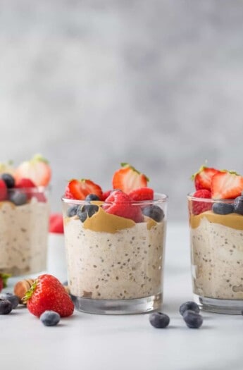 Glasses of overnight oats with chia seeds and fresh berries.