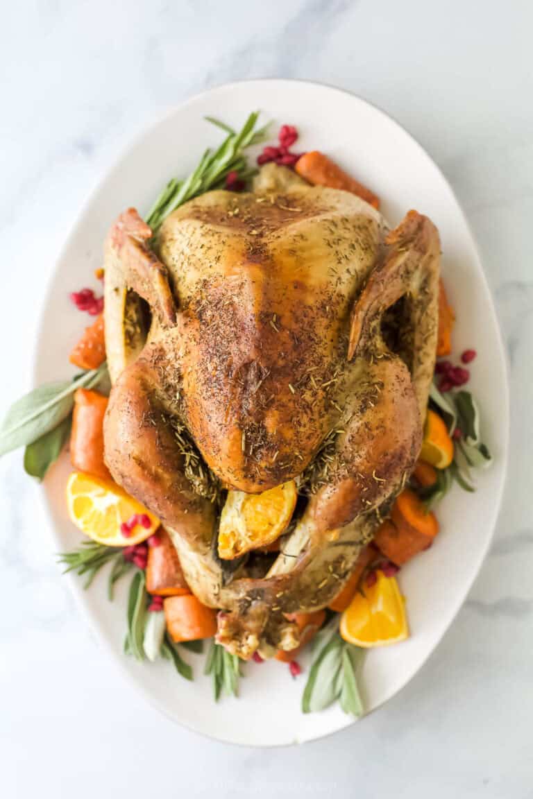 Roasted dry brine turkey with crispy, golden skin on a serving plate.