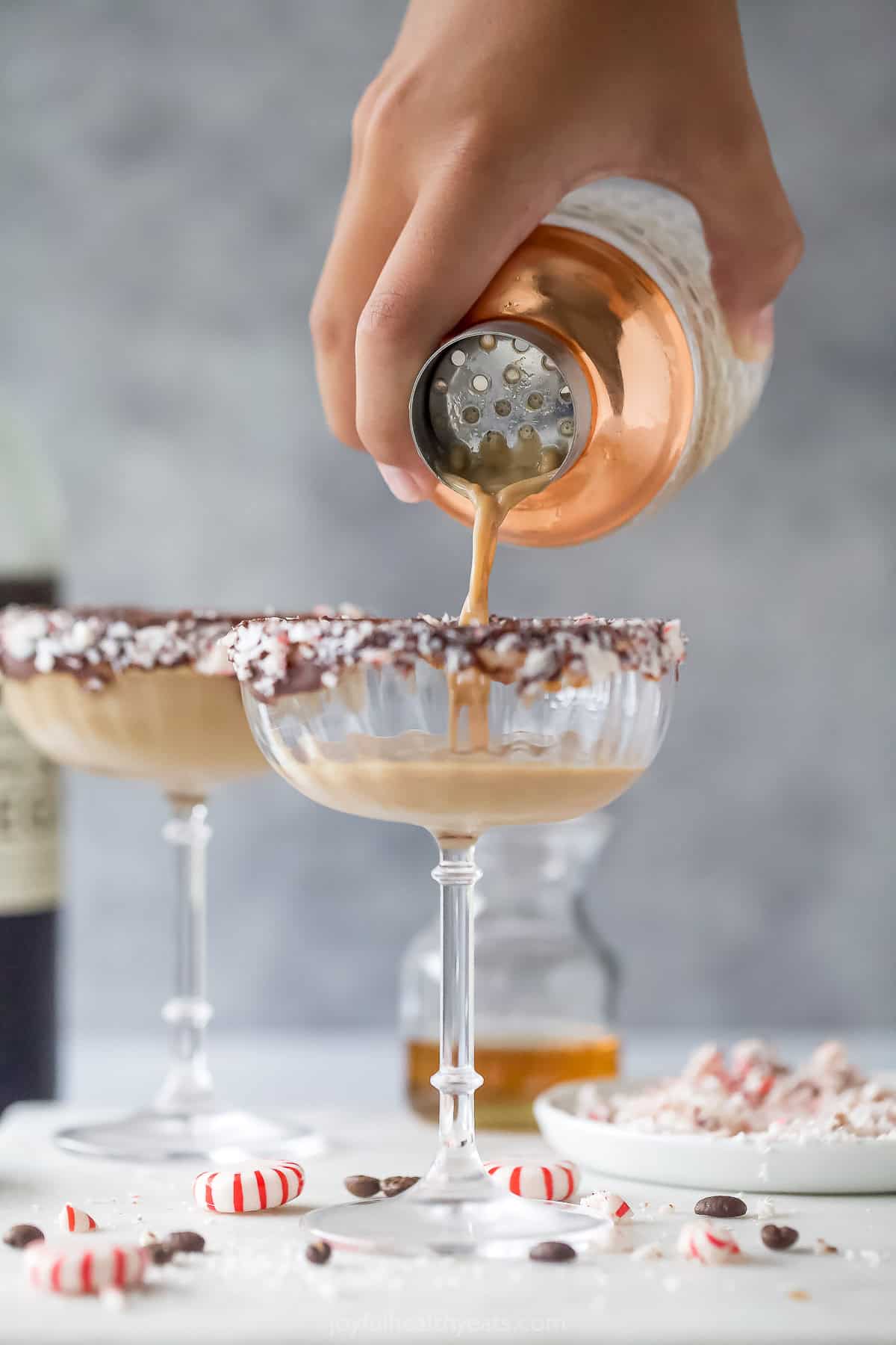 Pouring the cocktail into the rimmed glass. 