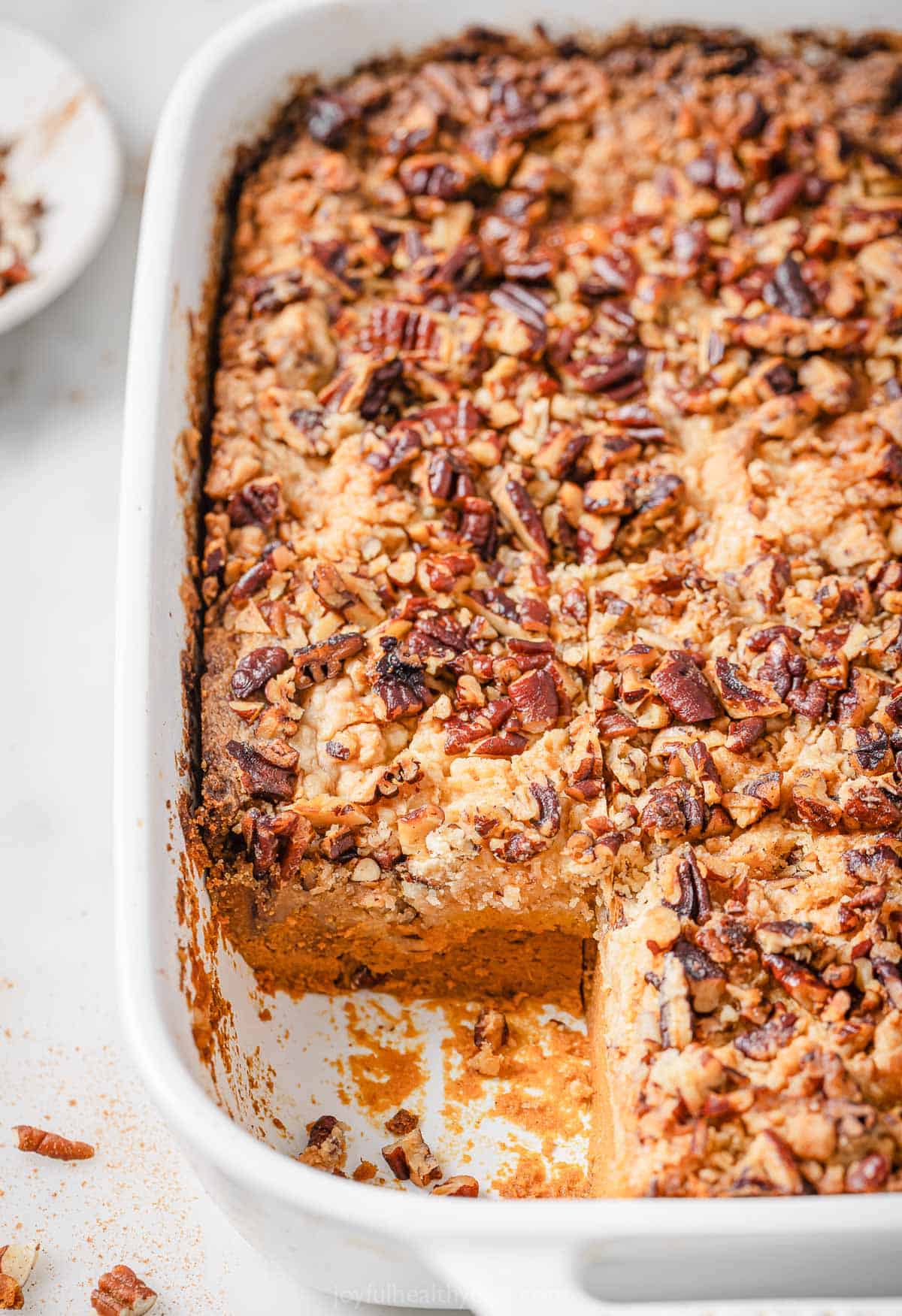 Pumpkin cake in the baking dish with crunchy pecans. 