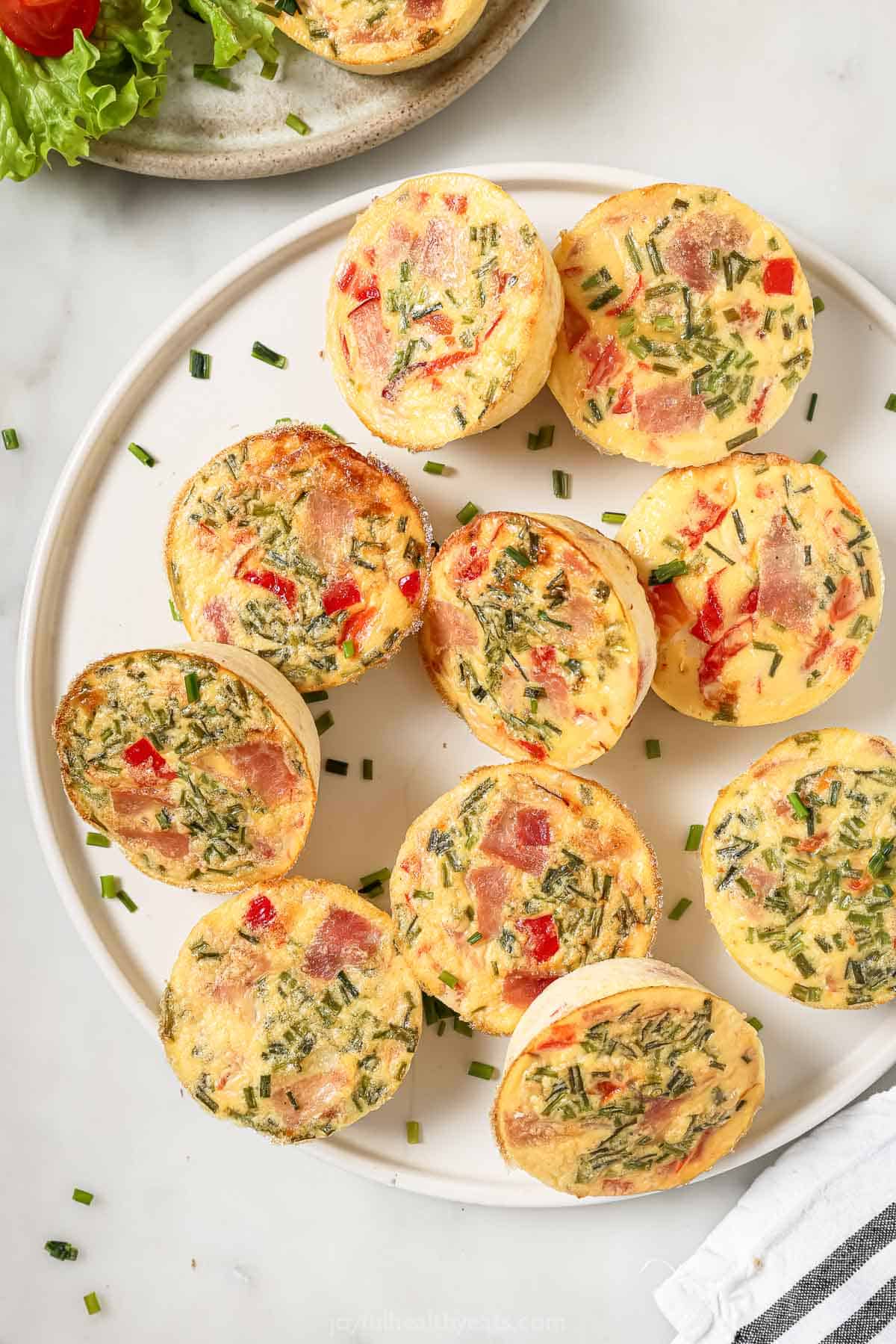 Overhead photo of cottage cheese egg bites with ham and roasted peppers on a serving plate.