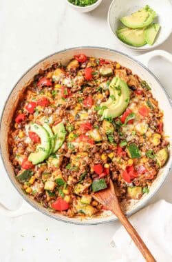 Ground beef and zucchini recipe with melty cheese, avocado, and tomatoes on top.