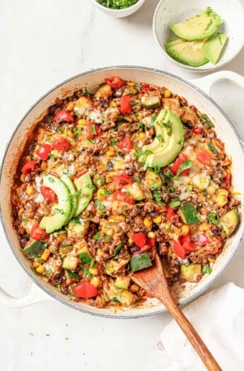 Ground beef and zucchini recipe with melty cheese, avocado, and tomatoes on top.