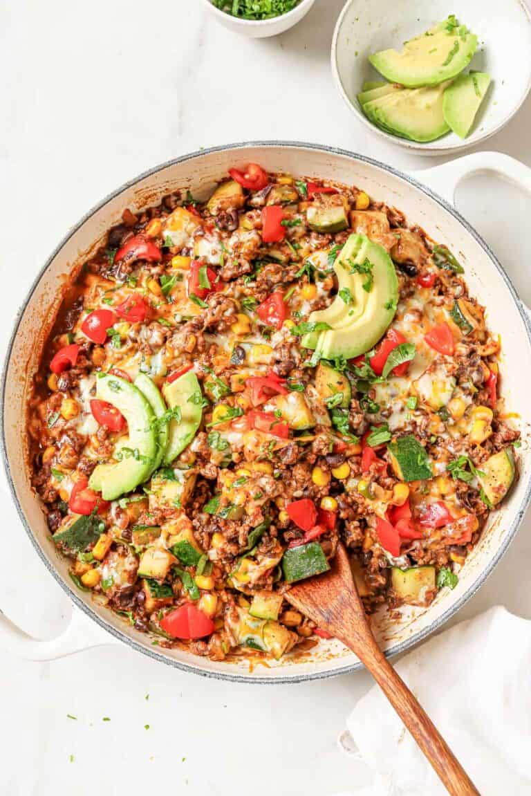 Ground beef and zucchini recipe with melty cheese, avocado, and tomatoes on top.