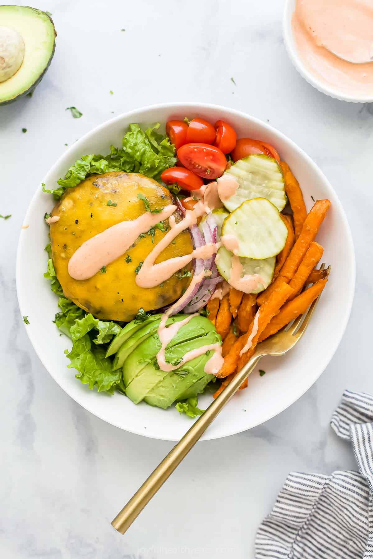 Assembled burger bowl recipe with special mayo-ketchup sauce drizzled on top. 