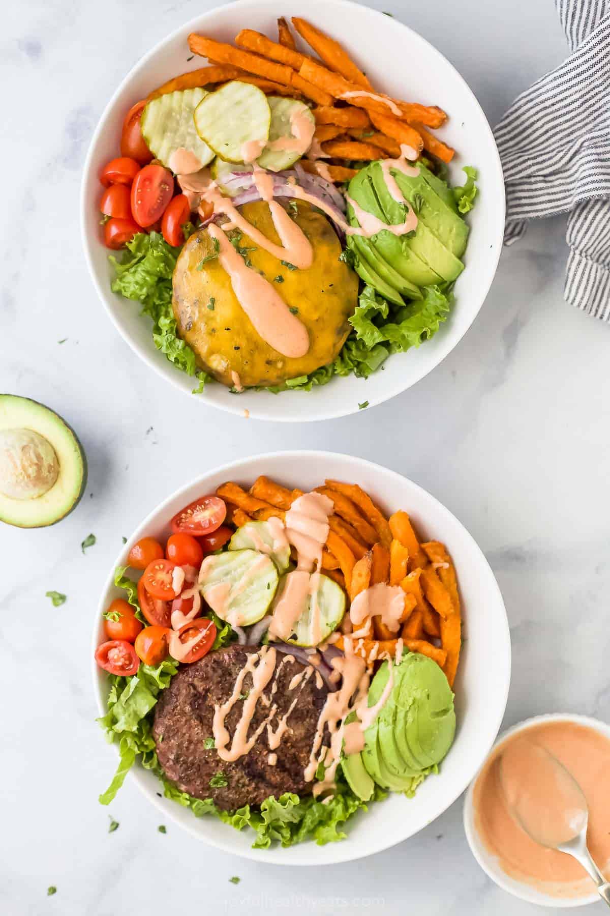 Two homemade burger bowls with sweet potato fries, melty cheddar, and special burger sauce on top. 