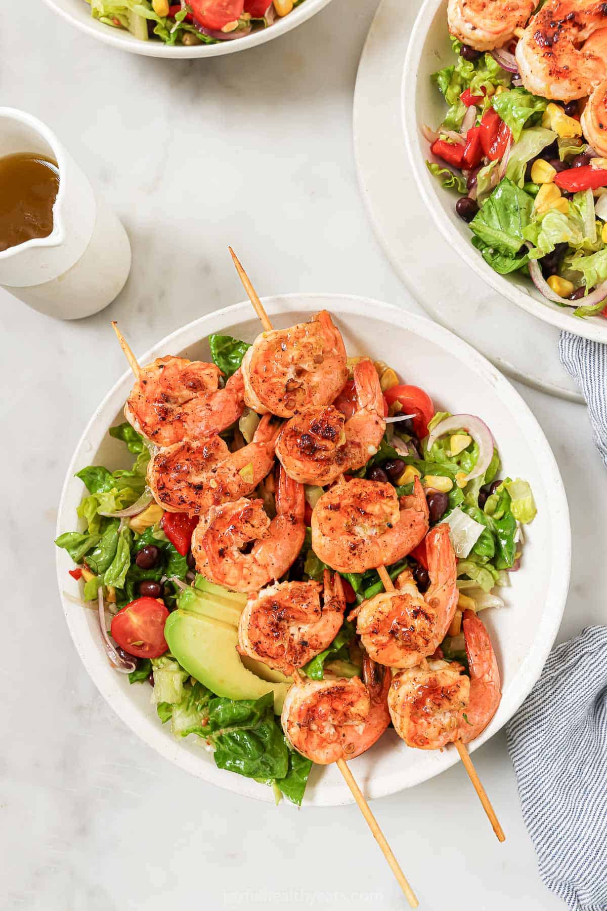 Overhead photo of spicy shrimp salad with a lettuce base and Tex-Mex add-ins. 