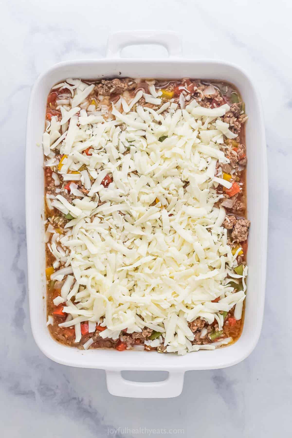 Topping the casserole with shredded mozzarella. 